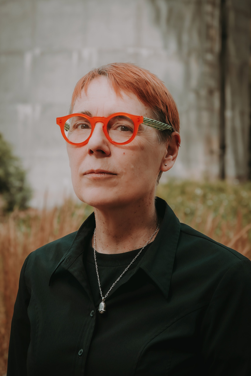 Image of Vivienne Tate from the torso up, wearing brightly coloured glasses